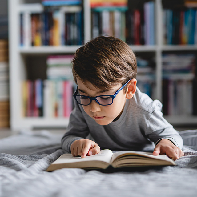 boy with glasses reading book